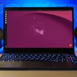 A laptop on a desk shows Ubuntu 26.10 Stonking Stingray desktop
