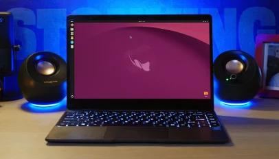 A laptop on a desk shows Ubuntu 26.10 Stonking Stingray desktop