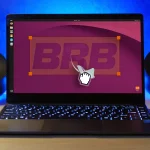 Grab cursor pulls ubuntu mascot out of laptop screen against word BRB