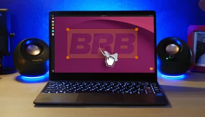 Grab cursor pulls ubuntu mascot out of laptop screen against word BRB